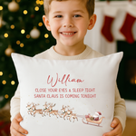 Child hugging Santa is Coming Tonight personalised cushion by Christmas tree.