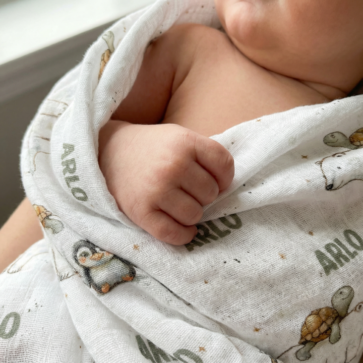 Personalised muslin swaddle wrap with baby name, soft breathable fabric, 120x120cm, ideal for newborns.