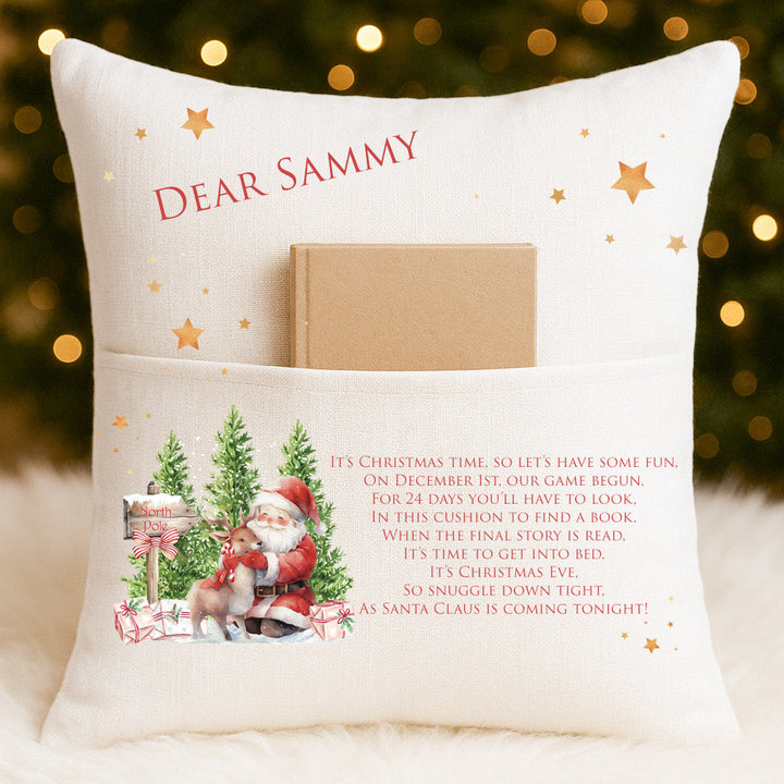 Personalised 24 Days of Christmas story cushion with Santa and reindeer design, linen-style fabric, and front pocket holding a Christmas book 