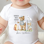 Baby wearing a soft cotton ‘World’s Best Daddy’ onesie with cute golfing design for first Father’s Day gift